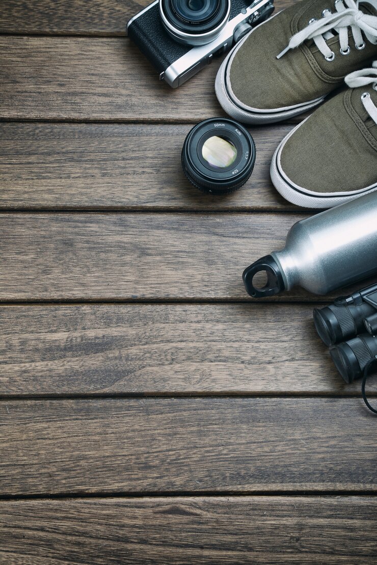 camera-lens-binocular-canvas-shoes-sports-bottle-retro-wooden-table_1387-34